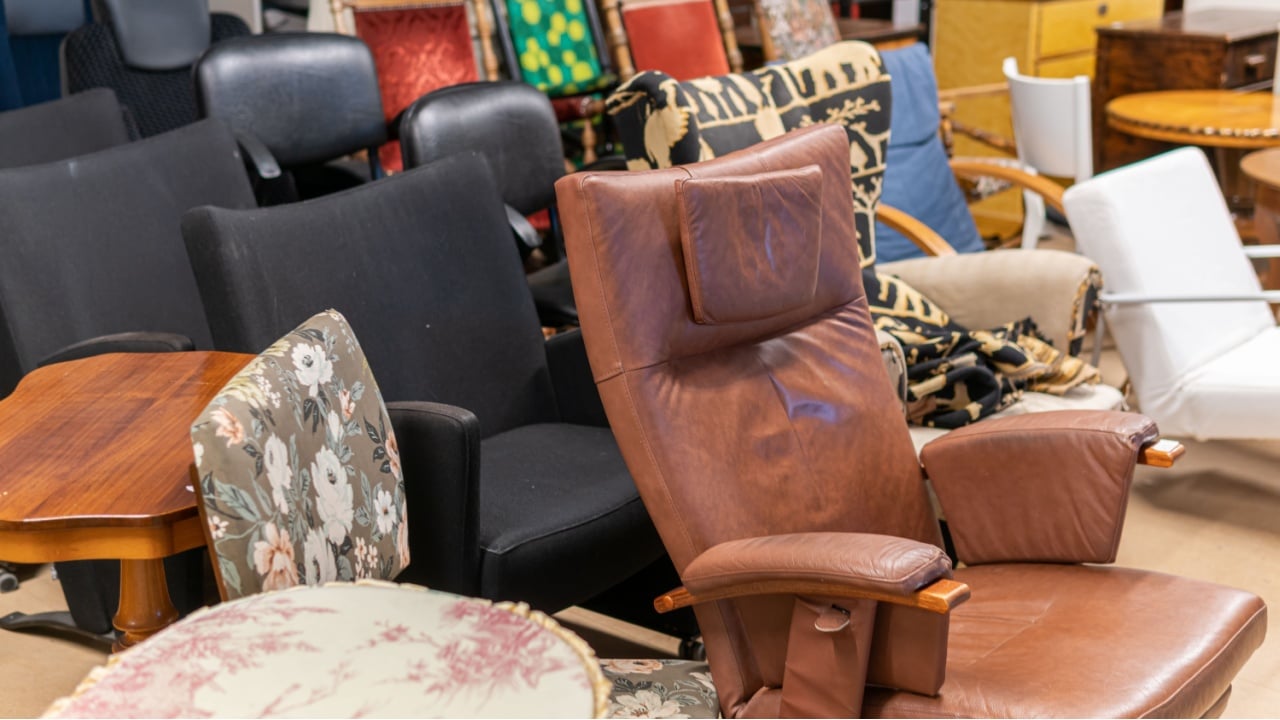 Sweden, Hanaskog – December 12, 2022: A big second hand store, a lot of used furniture sofas, chairs, tables, cupboards. Wooden furniture storage, warehouse. Vintage things.