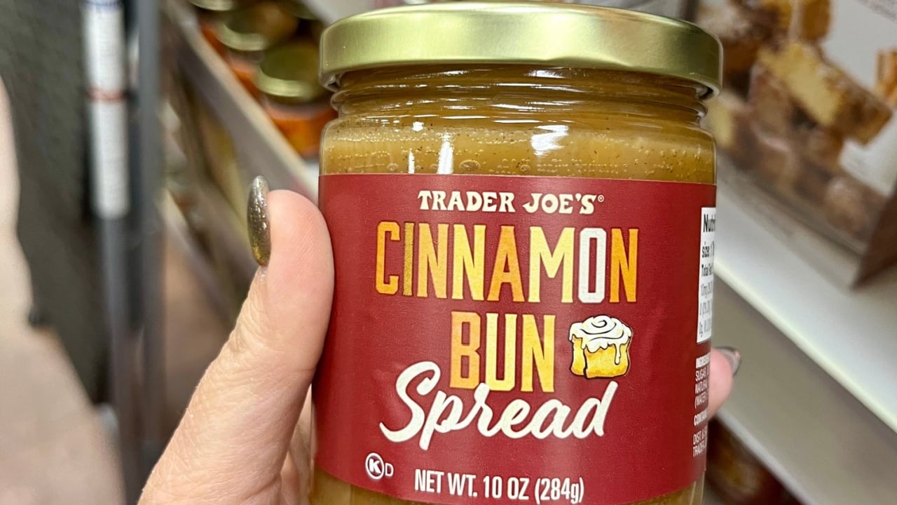 Lake Grove, NY, USA, 10.20.24 - A woman holding a jar of cinnamon bun spread at Trader Joe's.