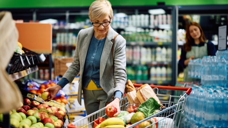 Senior woman buying at fresh fruit section in a supermarket.