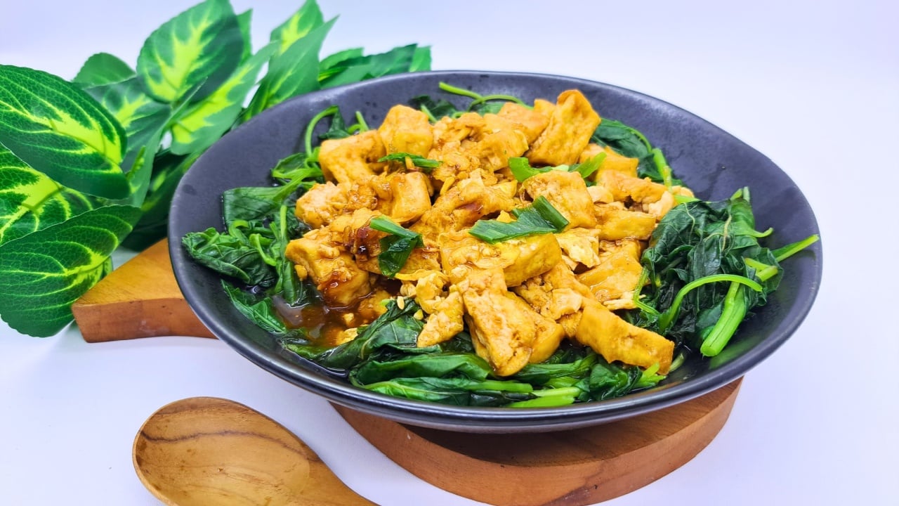 Delicious stir-fried tofu served with fresh green vegetables in savory sauce. Perfect for healthy food photography, vegan-friendly meal concepts, Asian cuisine stock images, and recipe content