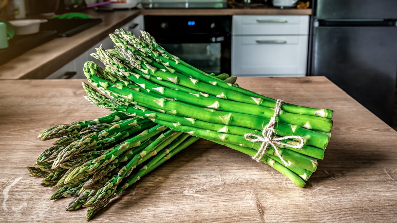 Organic green asparagus on a wooden kitchen table. Healthy food.