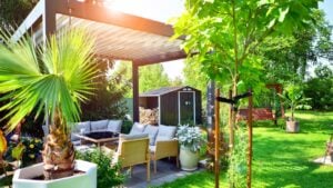 Modern aluminum pergola with stylish garden furniture in a beautiful garden.