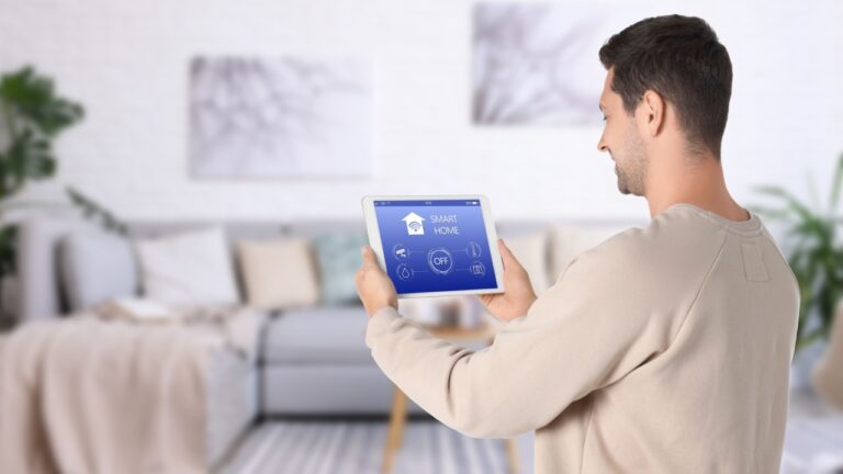 Man using smart home app on tablet computer to control house features