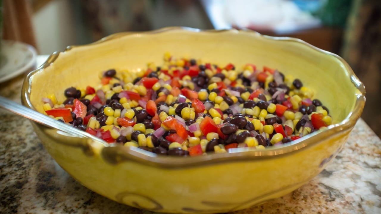 Mexican bean and corn salad salsa in giant yellow bowl