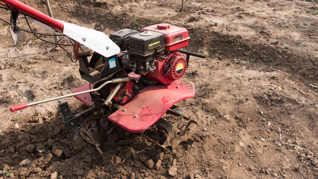 A small tilling machine is in the field.