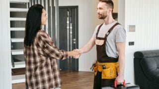 homeowner shaking hands with contractor invoice