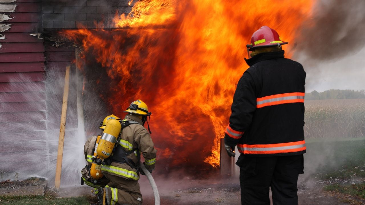Abandoned house in flame with firefighters in action
