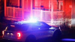 police car outside suburban home at night burglary investigation
