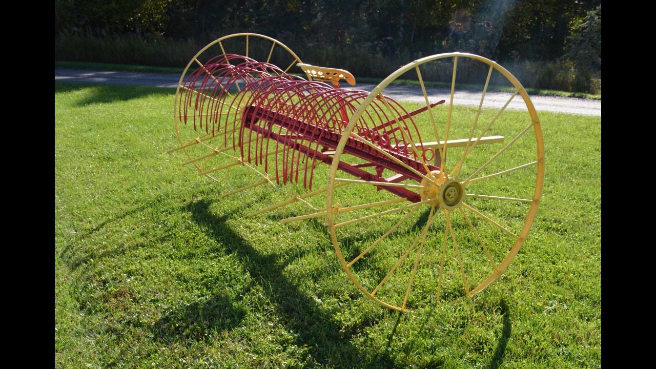 Vintage restored raking machine in farm setting