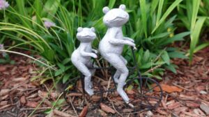 Garden ornament of two frog sitting on a bike.