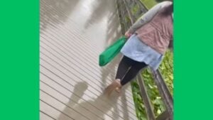 woman littering in lake.
