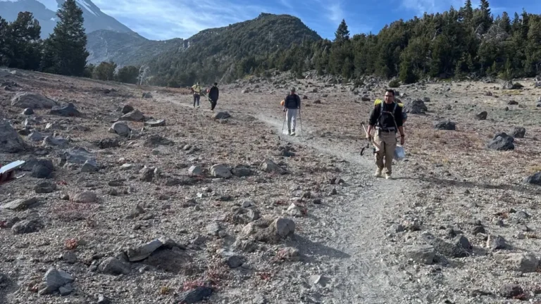 Three hikers climb mount shasta.